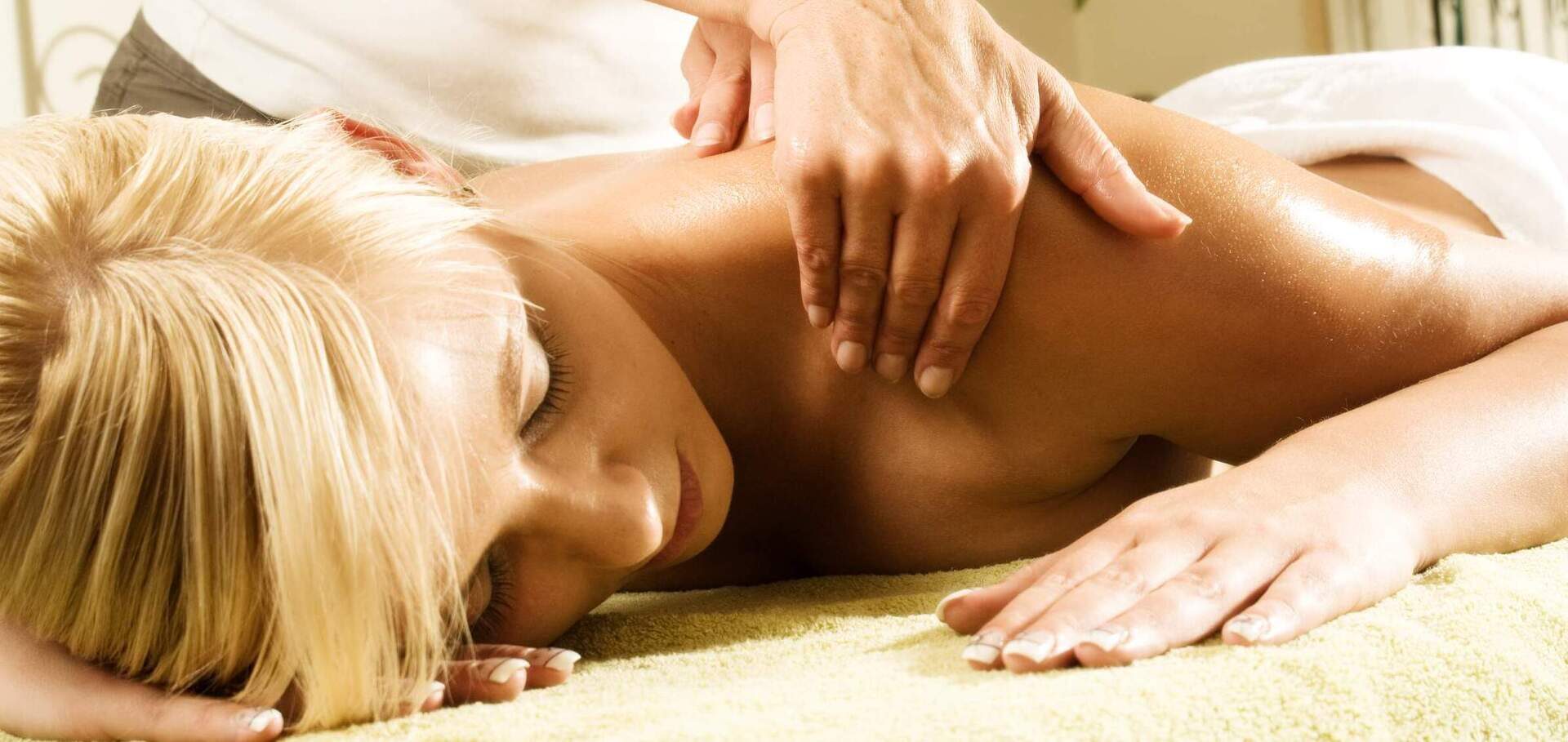Eine Frau erhält eine Massageanwendung im Wellnessbereich des Hotels in Bodenmais